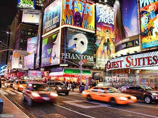 Times Square:
      Times Square is a major commercial intersection, tourist destination, entertainment center and neighborhood in the Midtown Manhattan section of New York City at the junction of Broadway and Seventh Avenue. It stretches from West 42nd to West 47th Streets. Brightly adorned with billboards and advertisements, Times Square is sometimes referred to as 'The Crossroads of the World', 'The Center of the Universe', 'the heart of The Great White Way', and the 'heart of the world'. One of the world's busiest pedestrian areas, it is also the hub of the Broadway Theater District and a major center of the world's entertainment industry.